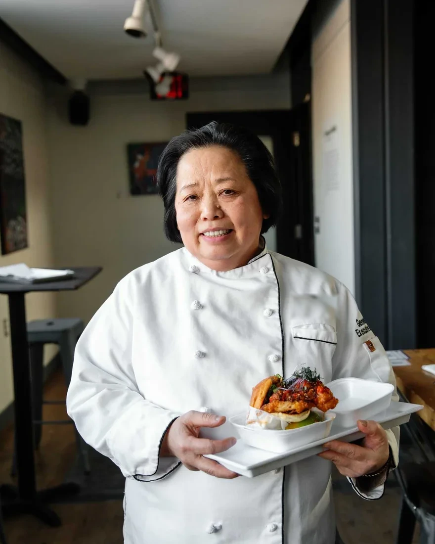 Chef Malee Suriya holding a plate of Thai street food at Golden Basil