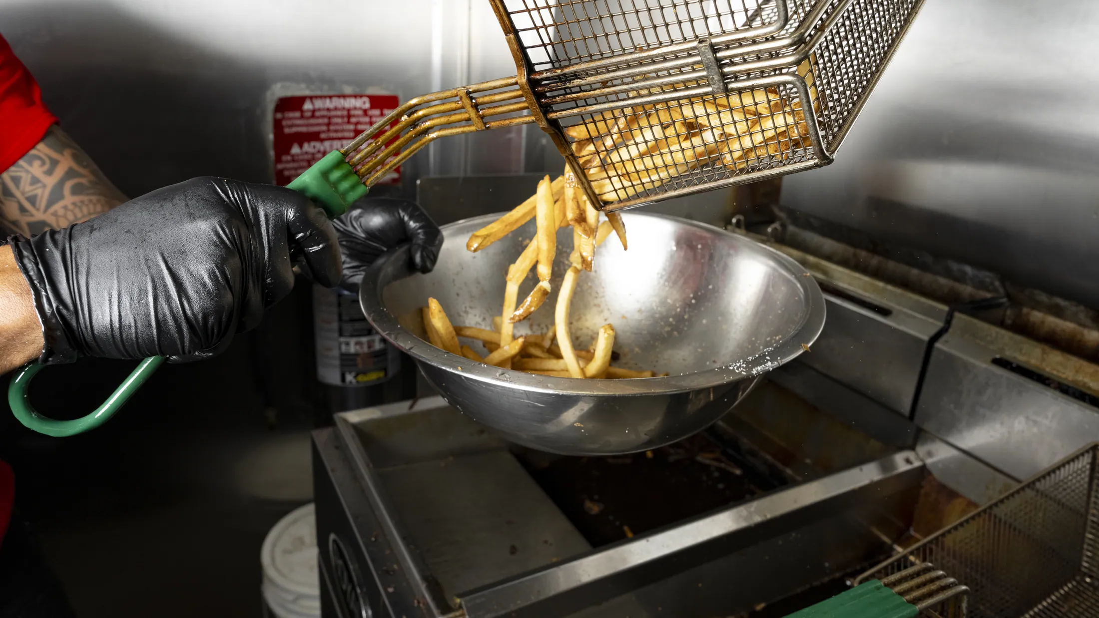 House-cut fries lifted from the fryer basket
