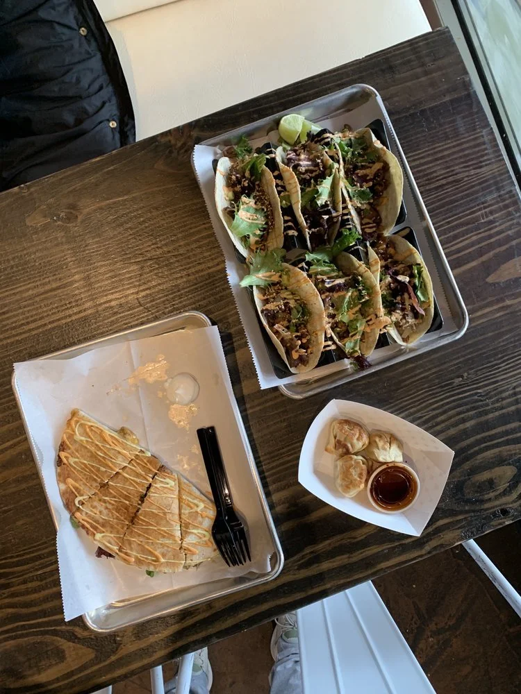 Tacos, quesadilla, and dumplings on the table at Gochu Cantina Example