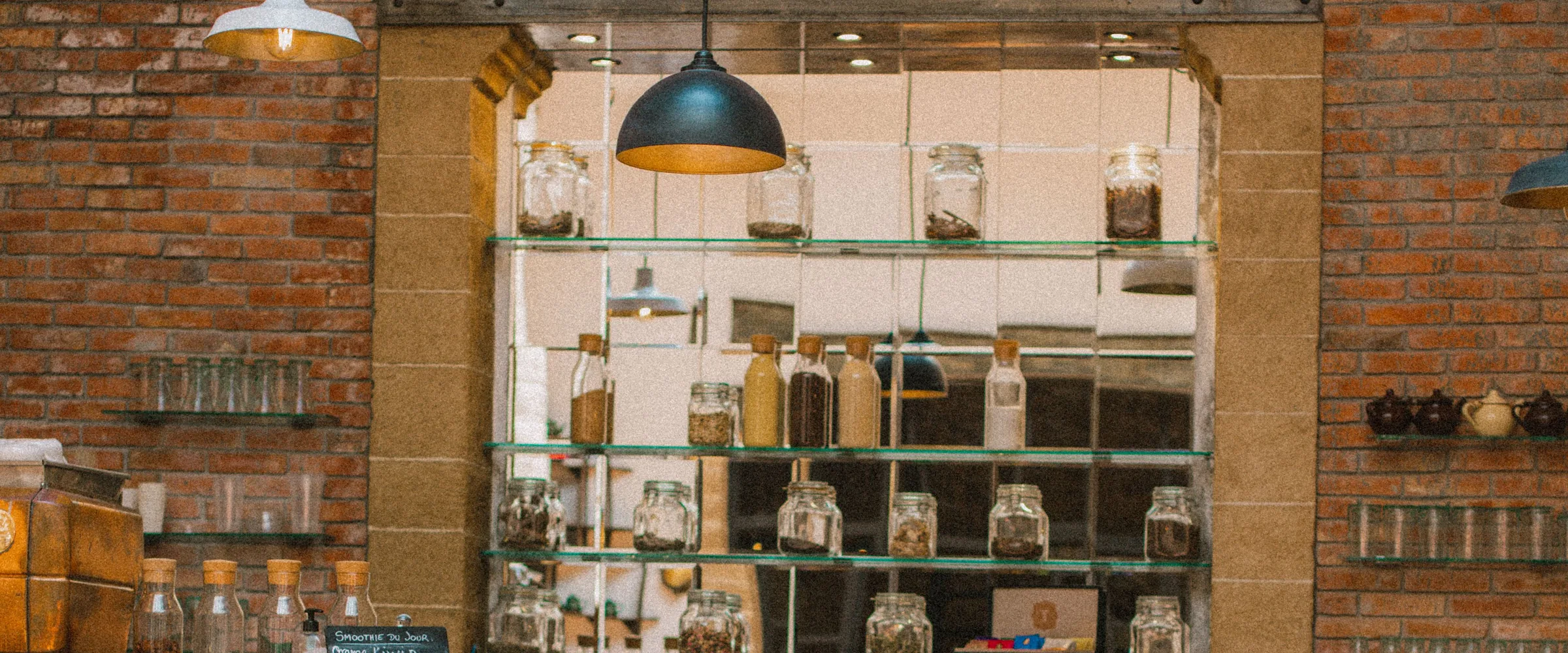 Brick walls, oak shelving and rows of glass jars behind the counter